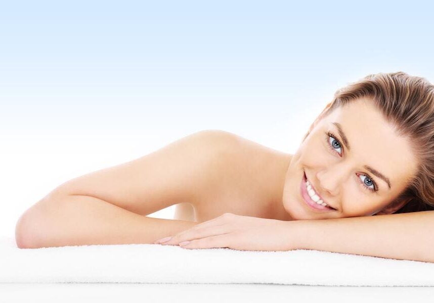 A smiling woman relaxing on a spa bed.