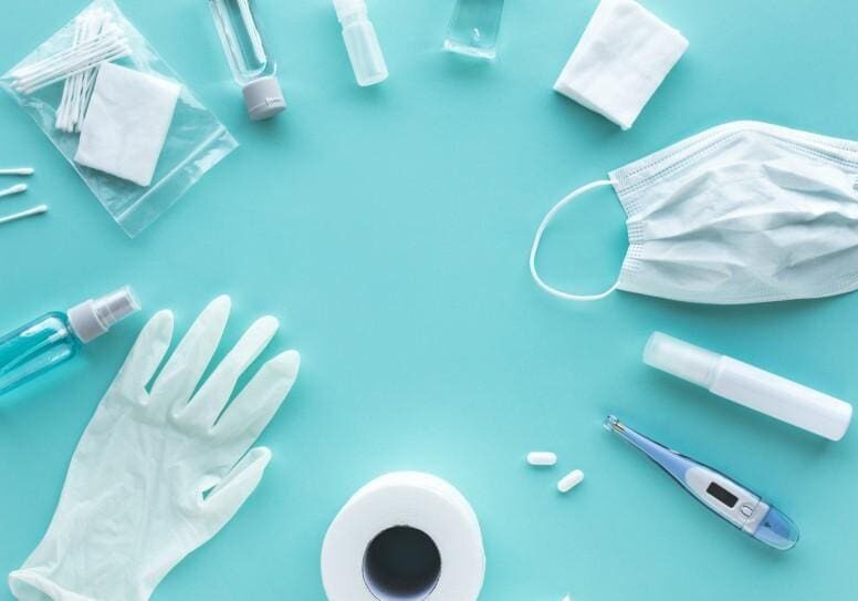 Sterile medical supplies including gloves, masks, and syringes on a blue surface.