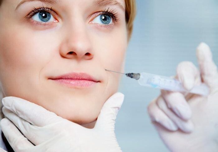 A woman receiving a cosmetic injection in her face.