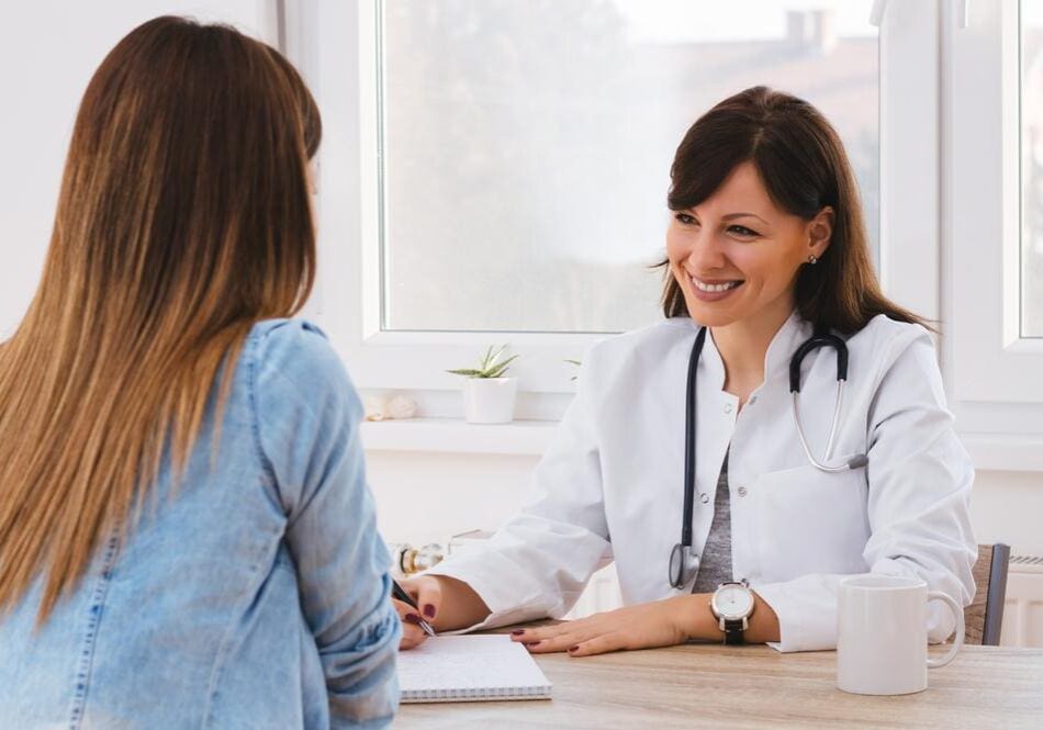 Doctor smiling and talking with a patient in the office.