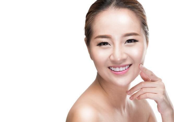 Smiling woman with clear skin and natural makeup.