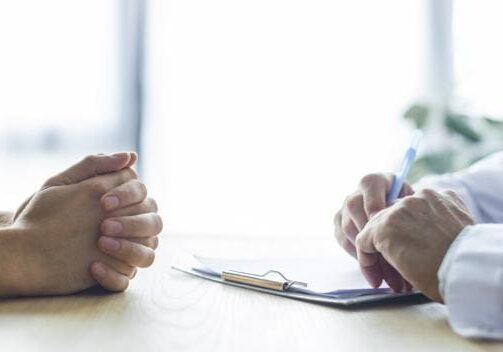 Two people engaged in a serious discussion over a clipboard.