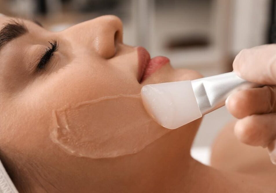 Applying a creamy facial mask with a soft brush.