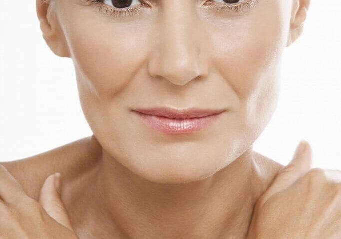 Close-up of a serene middle-aged woman with natural makeup and smooth skin.