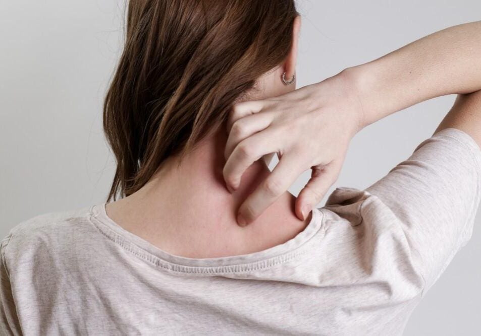 Person scratching an itchy spot on the back of their neck.