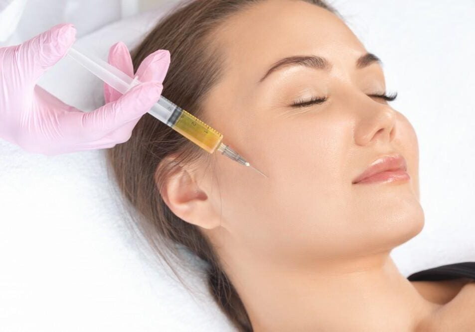 Woman receiving a facial injection treatment with closed eyes.